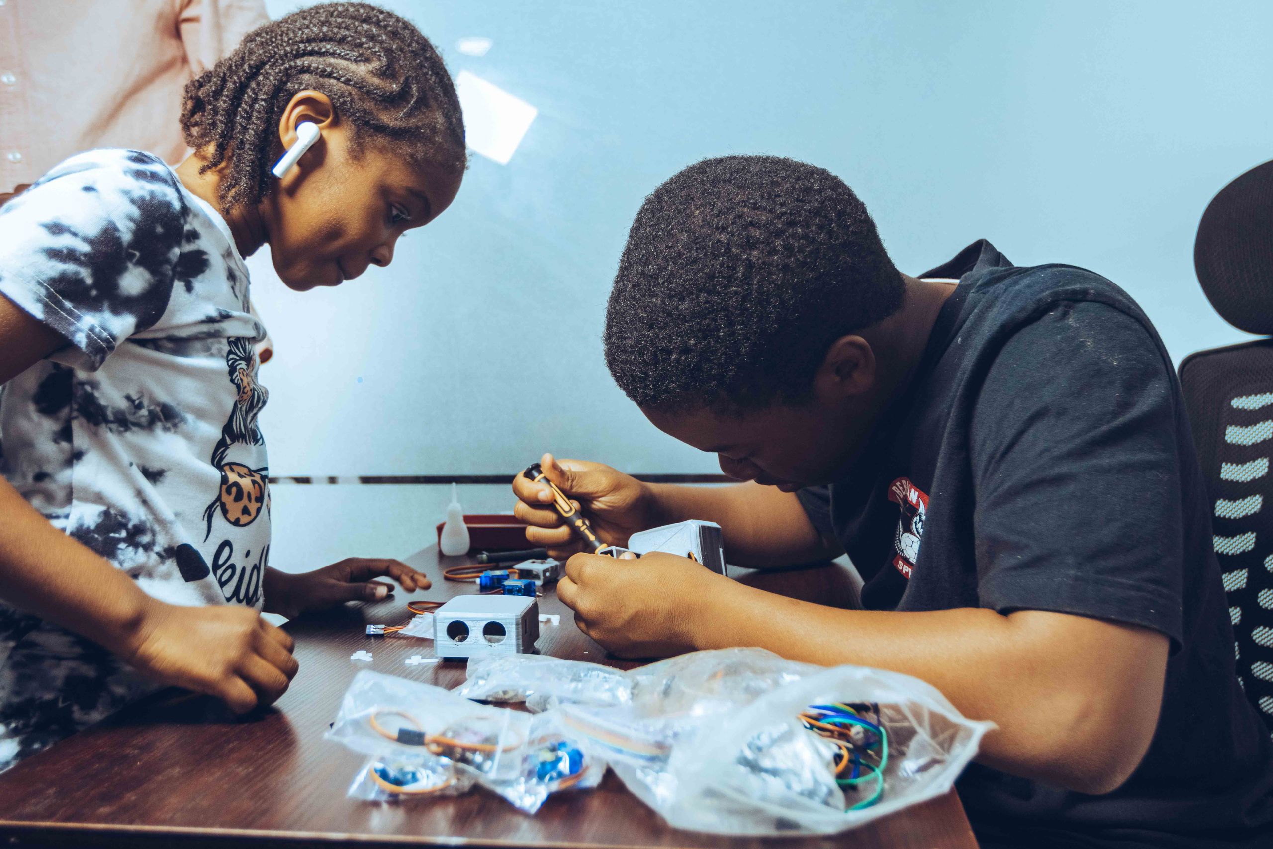 Two students engaged in hands-on electronics learning in a classroom